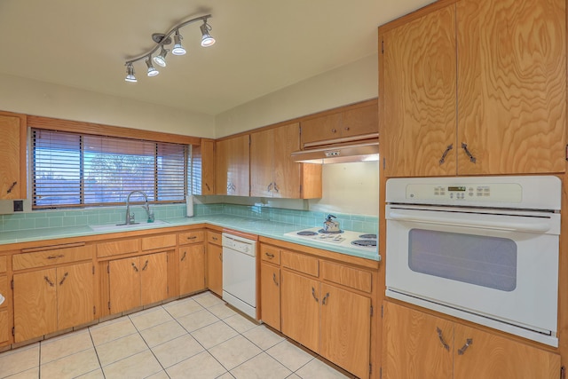 kitchen featuring backsplash, white appliances, sink, and light tile patterned floors