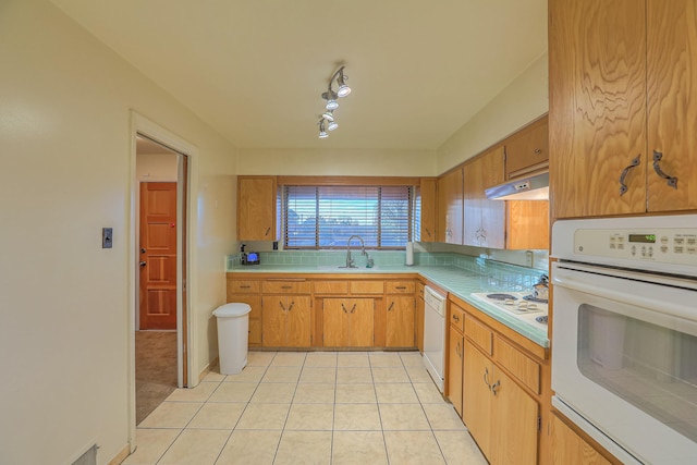 kitchen featuring sink, light tile patterned floors, and white appliances