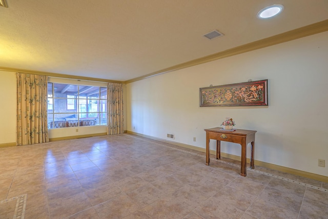 empty room featuring crown molding