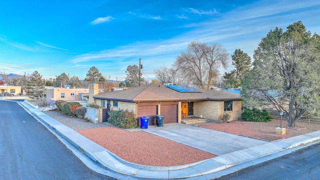 view of front of home with solar panels and a garage