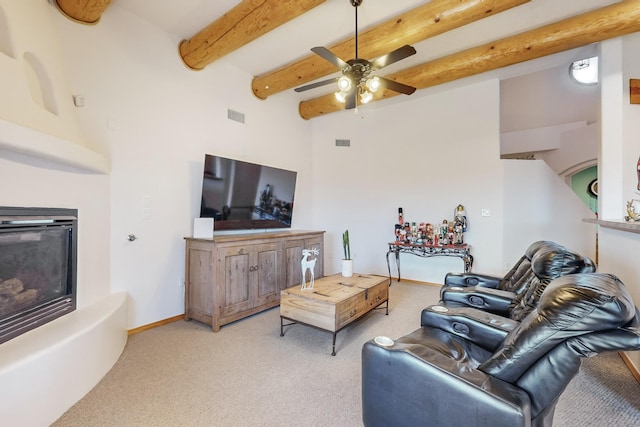 living room with beamed ceiling, ceiling fan, and light carpet