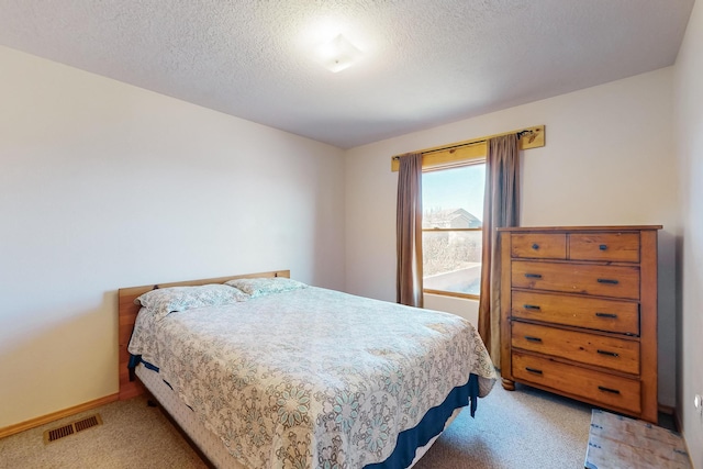 carpeted bedroom featuring a textured ceiling