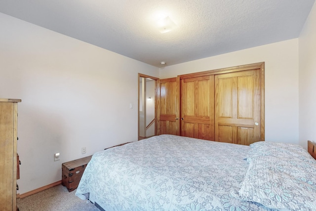 bedroom featuring carpet flooring, a textured ceiling, and a closet