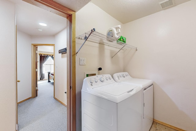 laundry area with separate washer and dryer and light carpet