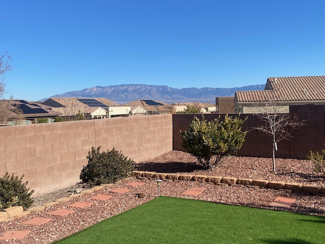 view of yard with a fenced backyard and a mountain view