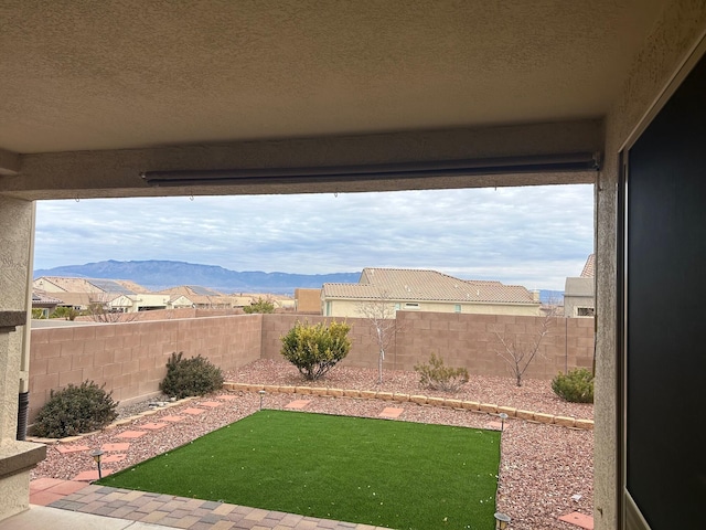 view of yard with a fenced backyard and a mountain view