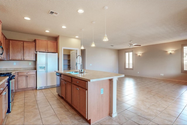 kitchen with ceiling fan, stainless steel appliances, a sink, open floor plan, and light countertops