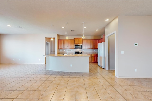 kitchen featuring a kitchen island with sink, light tile patterned floors, pendant lighting, and appliances with stainless steel finishes