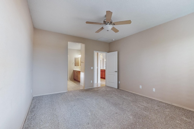 unfurnished bedroom with light colored carpet, ensuite bath, and ceiling fan