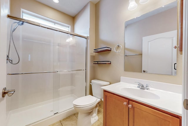 bathroom featuring tile patterned flooring, vanity, toilet, and a shower with door