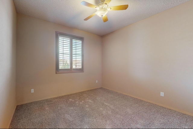 empty room featuring a textured ceiling, carpet, a ceiling fan, and baseboards