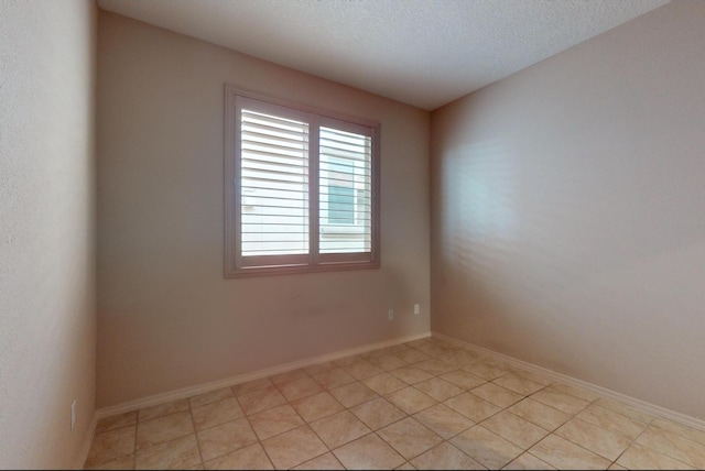 tiled empty room with a textured ceiling