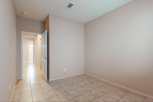 unfurnished room with light tile patterned floors, baseboards, and visible vents