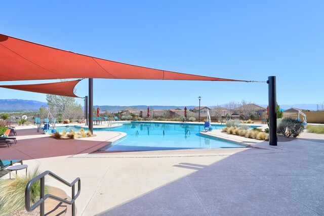 view of swimming pool with a mountain view and a patio