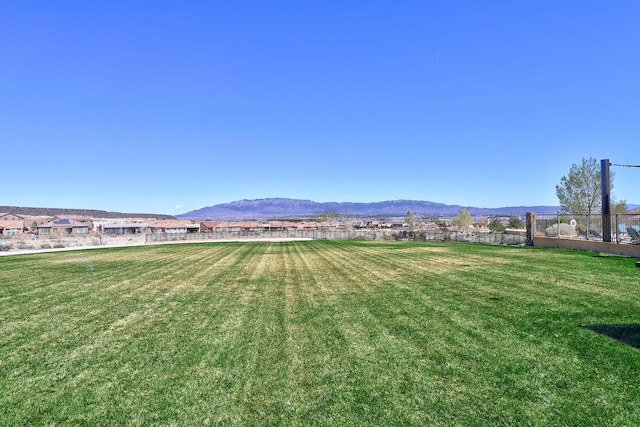 view of yard featuring fence and a mountain view