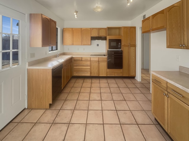 kitchen with black appliances, light tile patterned floors, and sink