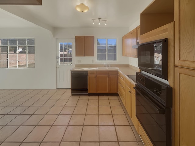 kitchen featuring light brown cabinetry, light tile patterned flooring, black appliances, and sink