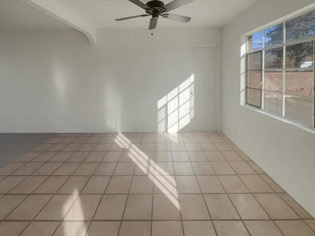 tiled spare room with ceiling fan