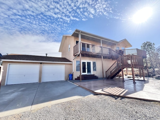 back of property with a balcony and a garage