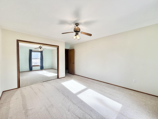 unfurnished bedroom featuring ceiling fan, a closet, and light colored carpet