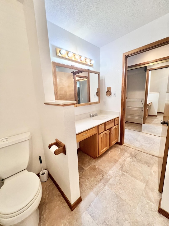 bathroom with vanity, a textured ceiling, and toilet