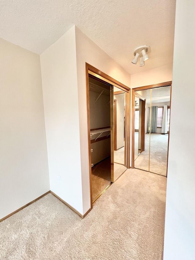 corridor with carpet and a textured ceiling