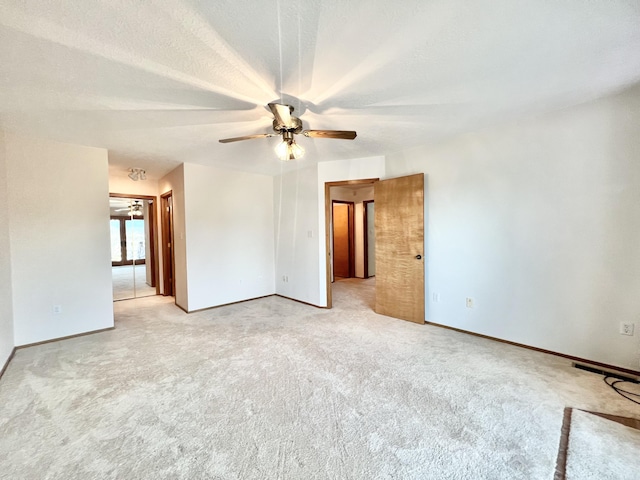 carpeted empty room with ceiling fan and a textured ceiling