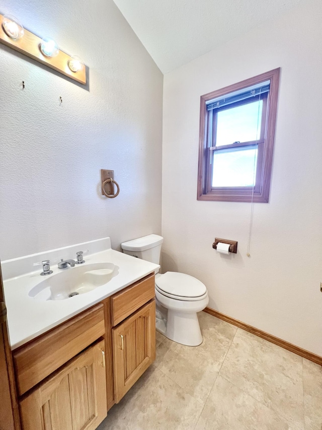 bathroom with tile patterned flooring, vanity, and toilet