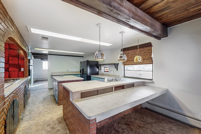 kitchen featuring light carpet, black refrigerator with ice dispenser, baseboard heating, sink, and an island with sink