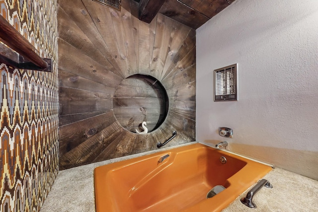 bathroom with a bathing tub and wood ceiling