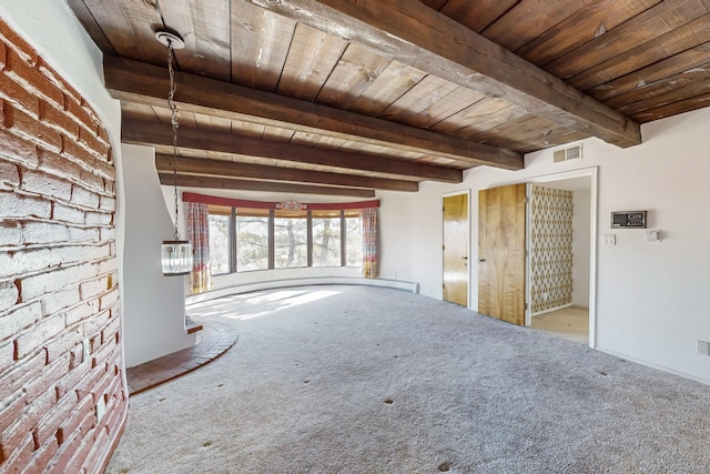 interior space featuring beamed ceiling, light colored carpet, wooden ceiling, and brick wall