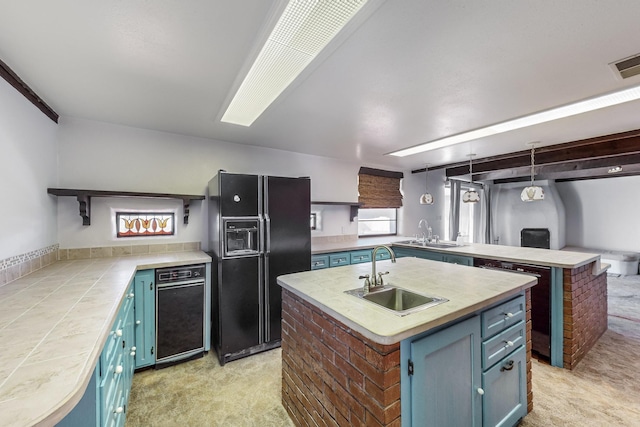 kitchen featuring sink, hanging light fixtures, black refrigerator with ice dispenser, light colored carpet, and a kitchen island with sink