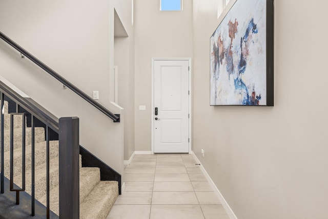 tiled foyer featuring a towering ceiling