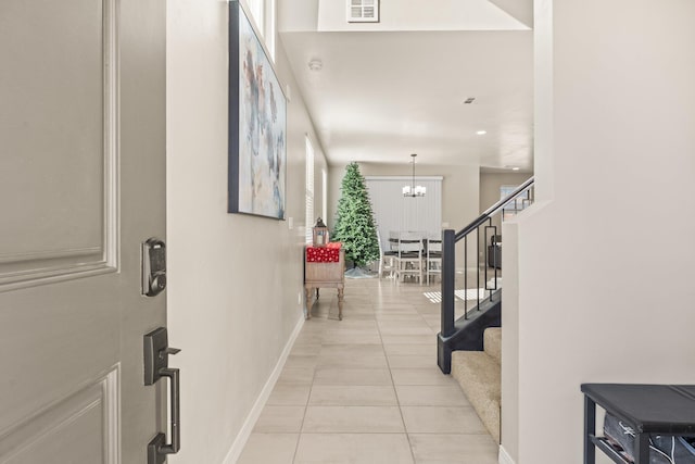 tiled entryway featuring a chandelier