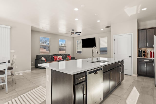 kitchen featuring sink, dark brown cabinets, a center island with sink, light tile patterned floors, and dishwasher