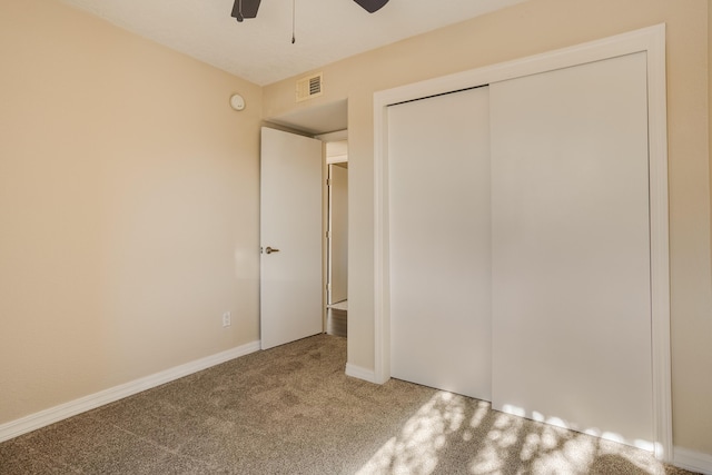 unfurnished bedroom with ceiling fan, a closet, and carpet