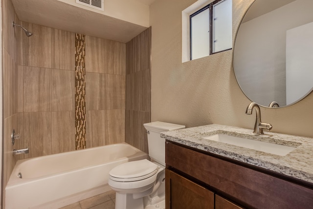 full bathroom with tile patterned flooring, tiled shower / bath combo, toilet, and vanity