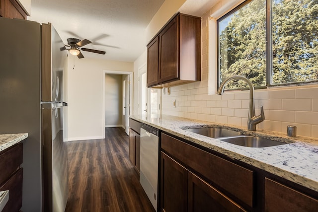 kitchen featuring backsplash, dark hardwood / wood-style flooring, light stone counters, stainless steel appliances, and sink