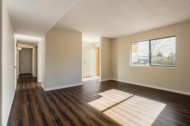 unfurnished room with dark hardwood / wood-style flooring and a textured ceiling