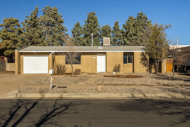 ranch-style home featuring a garage and central AC unit