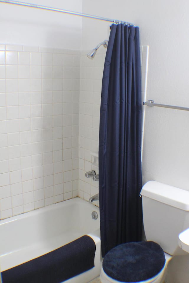 bathroom featuring shower / bathtub combination with curtain and toilet