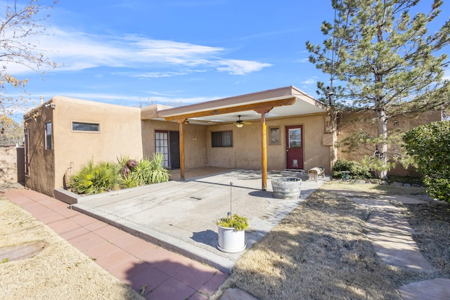 back of house with ceiling fan and a patio area