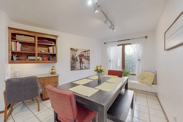 dining room featuring rail lighting and light tile patterned floors