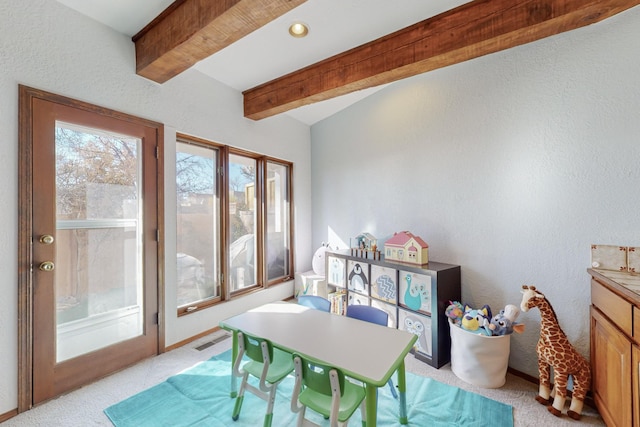 rec room with beam ceiling and light carpet