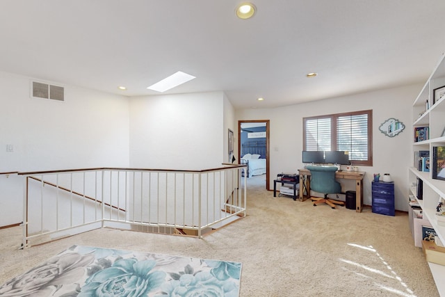 carpeted office space with a skylight