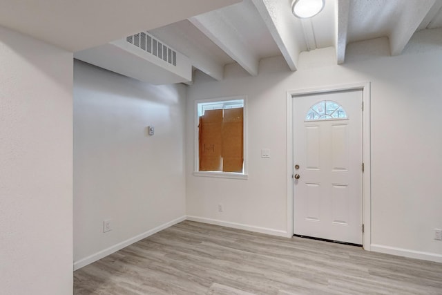 entrance foyer featuring beamed ceiling and light hardwood / wood-style floors