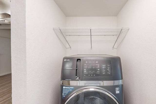 washroom with hardwood / wood-style floors and washer / dryer