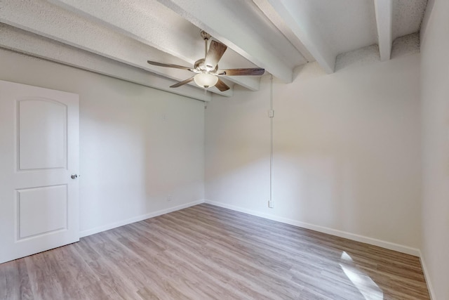 spare room with beam ceiling, ceiling fan, and light wood-type flooring