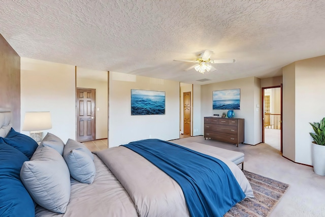 carpeted bedroom featuring a textured ceiling and ceiling fan