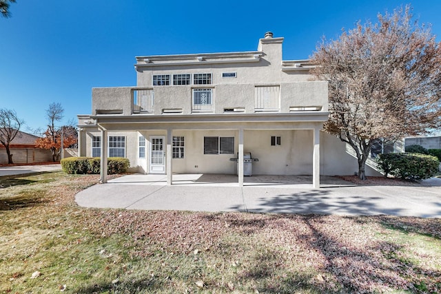 back of property featuring a balcony and a patio area